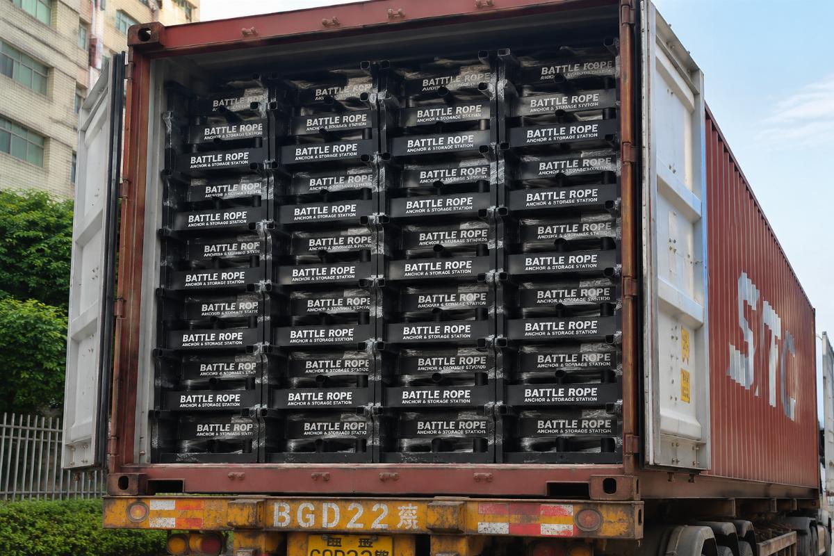 A full 40HQ shipping container loaded with stacked battle rope anchor and storage station units