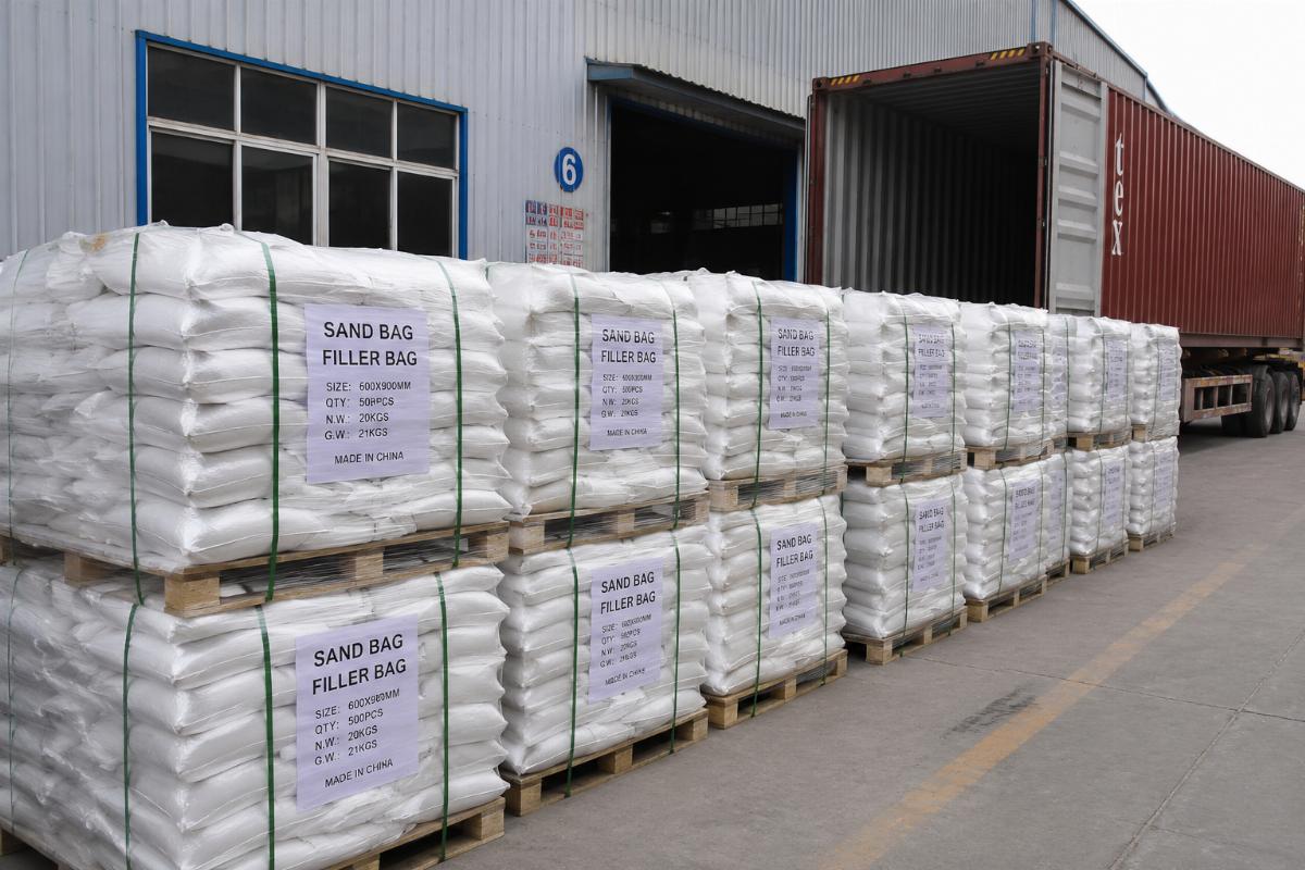 Bulk stack of sandbag filler bags ready for container shipment at a manufacturing facility
