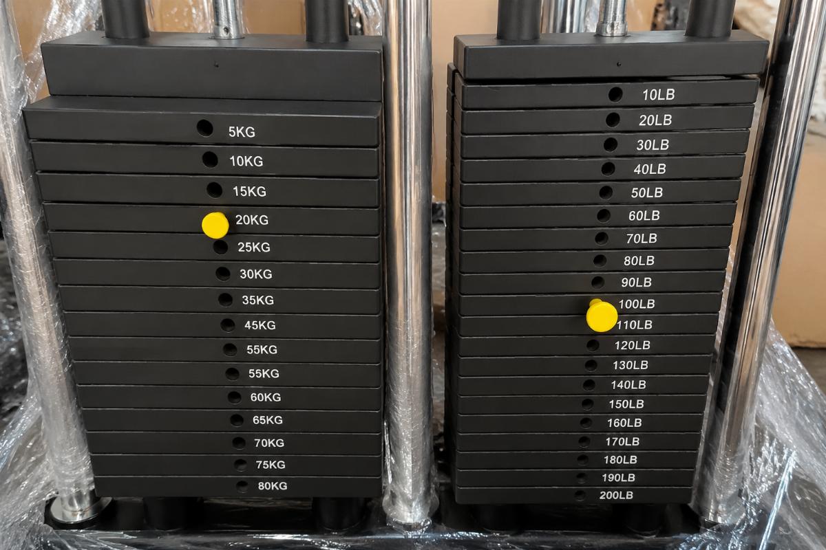Close-up of mismatched weight stack pins and guide rods from a mixed-configuration gym equipment shipment