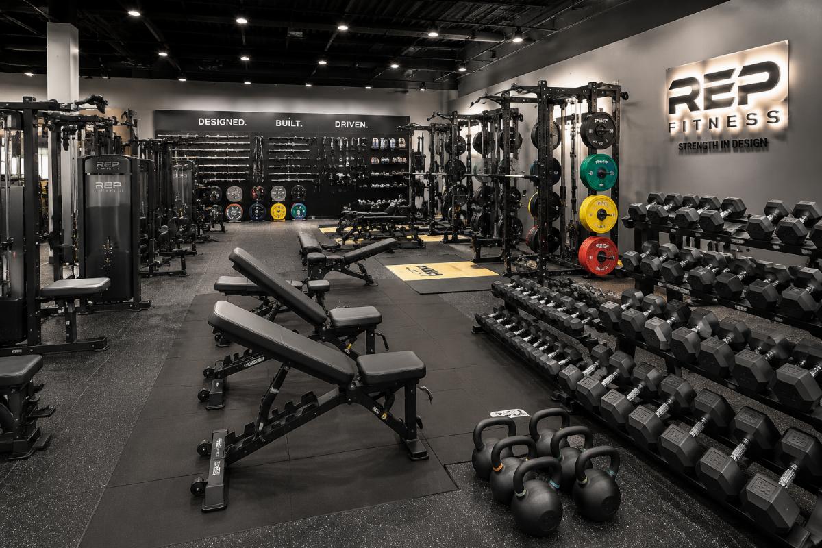 Commercial strength equipment and free weights arranged in a gym showroom