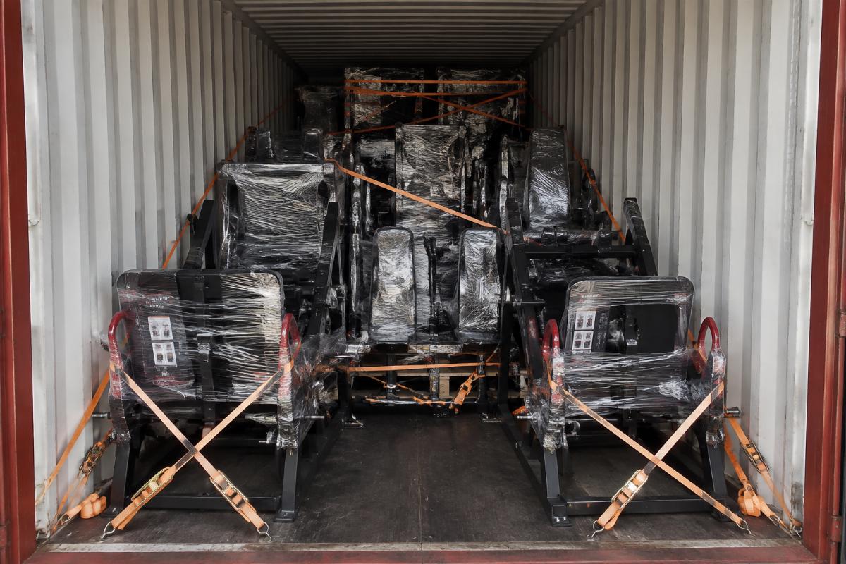Full container loaded with turnkey hack squat machines and complementary strength equipment wrapped and secured for multi-site international shipment