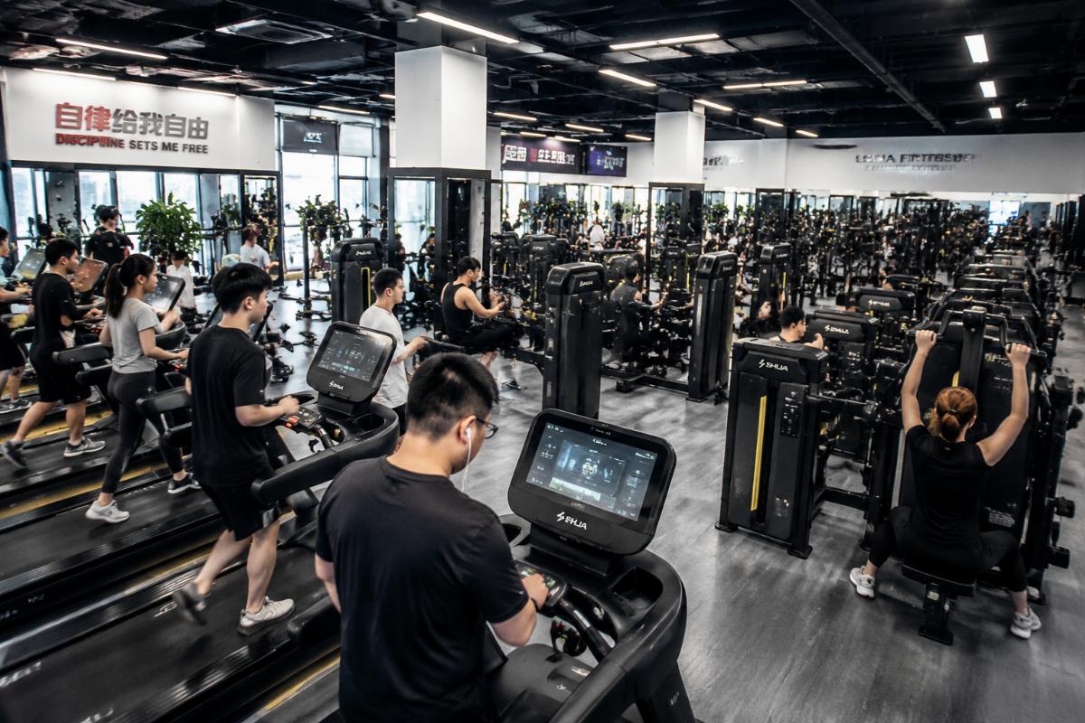 High-traffic commercial gym floor with Chinese-manufactured cardio and strength equipment in daily use