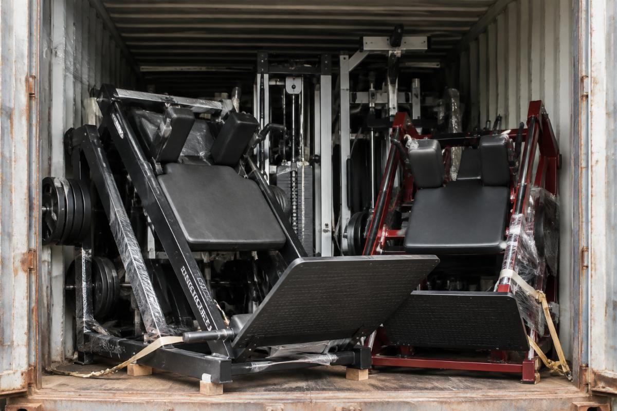 Mixed container load of commercial gym equipment including hack squat machines