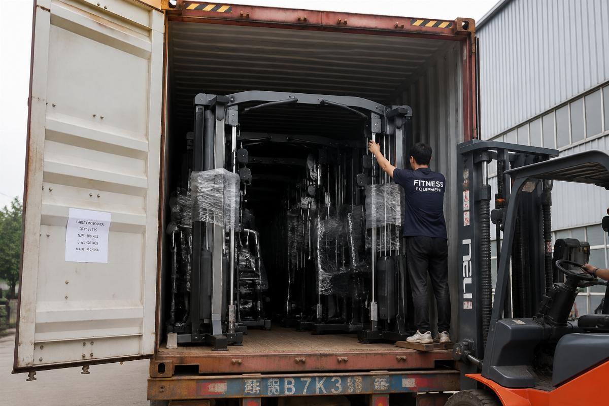 Multiple pieces of commercial gym equipment including cable crossover being loaded into a shipping container